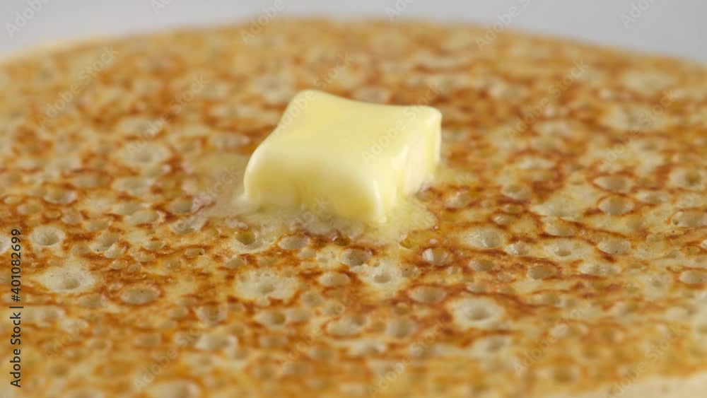 Macro shooting. A lump of butter melts on a stack of hot pancakes