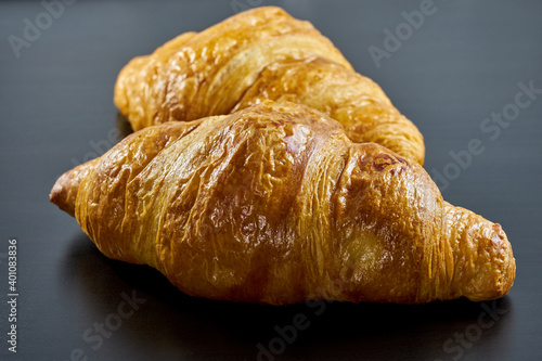 Freshly baked French croissants on a dark background.