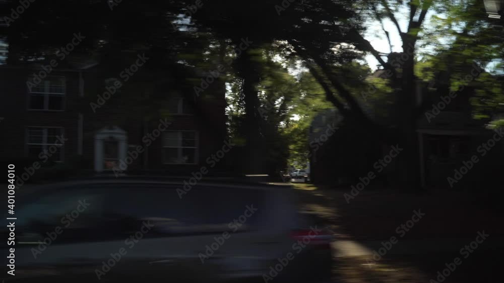 Driving shot from passengers perspective and point of view looking at suburban homes, sidewalks, and green lawns during a sunny spring daytime in Columbus, Ohio around Grandview Heights Driving shot from passengers perspective and point of view looking at suburban homes, sidewalks, and green lawns during a sunny spring daytime in Columbus, Ohio around Grandview Heights