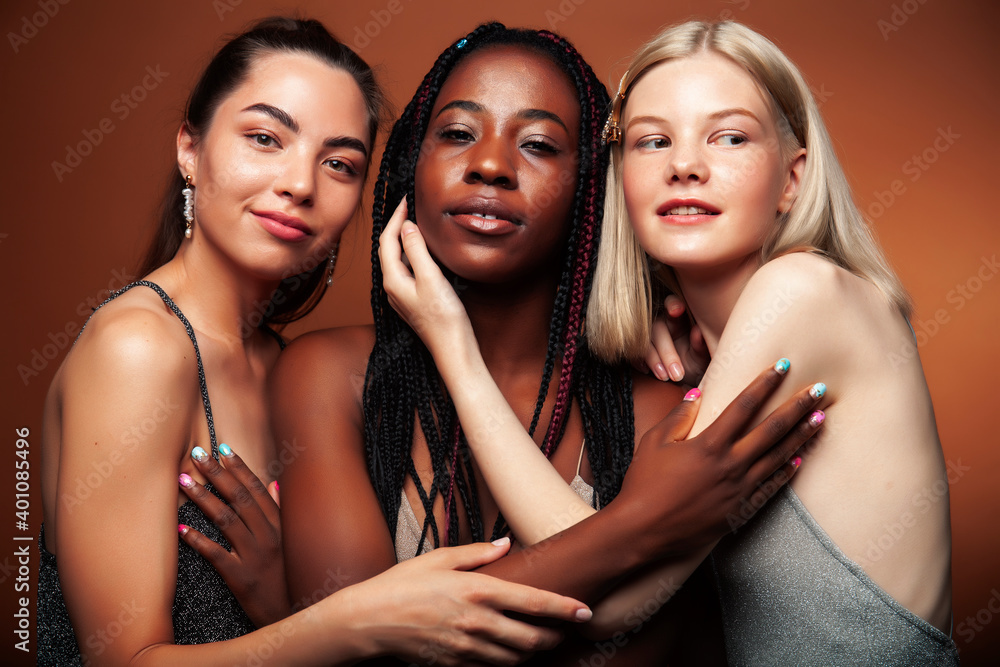 young pretty caucasian, afro, asian woman posing cheerful together on brown background, lifestyle diverse nationality people concept young pretty caucasian, afro, asian woman posing cheerful together on brown background, lifestyle diverse nationality people concept