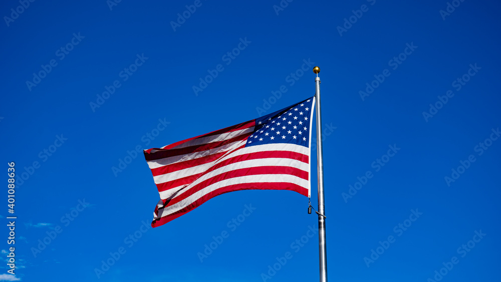 Obraz premium USA Flag waving in the blue sky