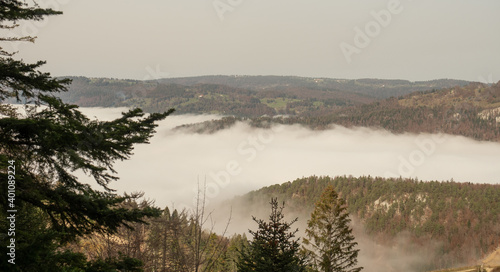 View from hiking trail to Chasseral into a valley filled with fog 