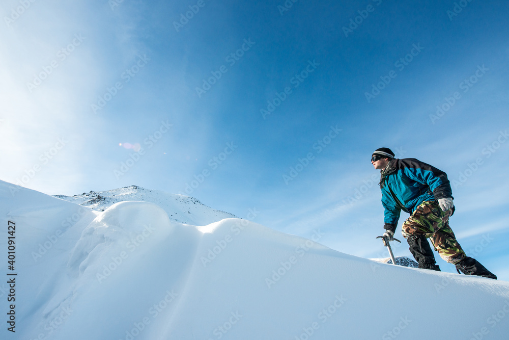 climber with an ice ax in the snowy mountains climber with an ice ax in the snowy mountains