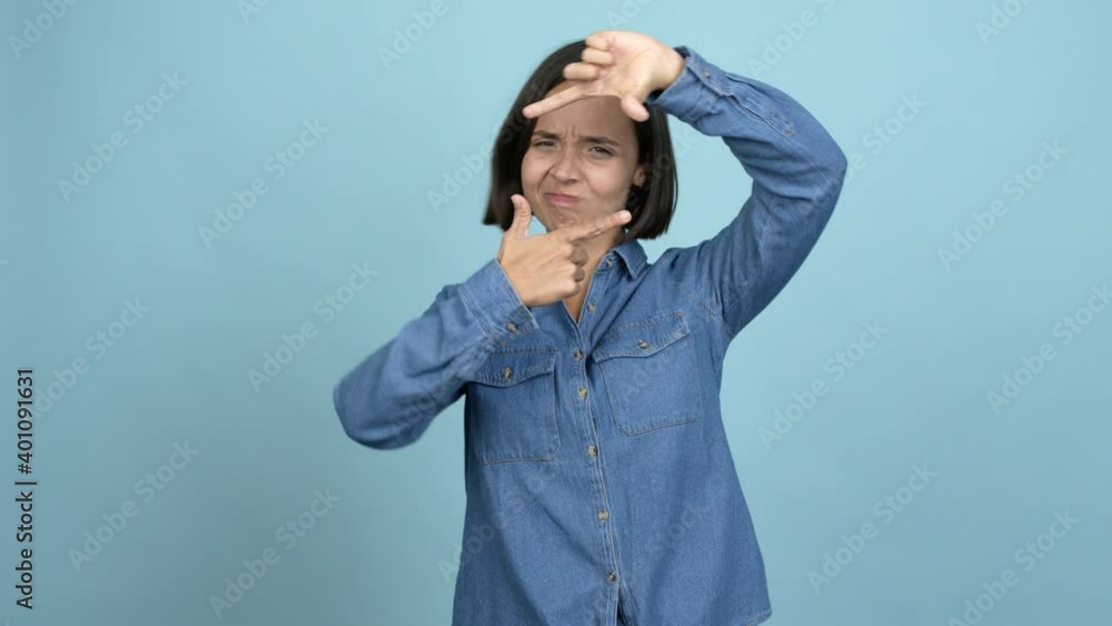 Young latin woman focusing with fingers over isolated background Young latin woman focusing with fingers over isolated background