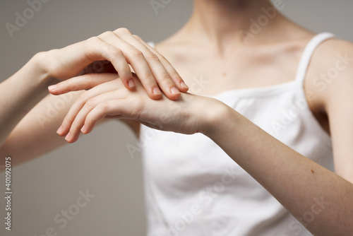 slender woman touching her hands on beige background cropped view