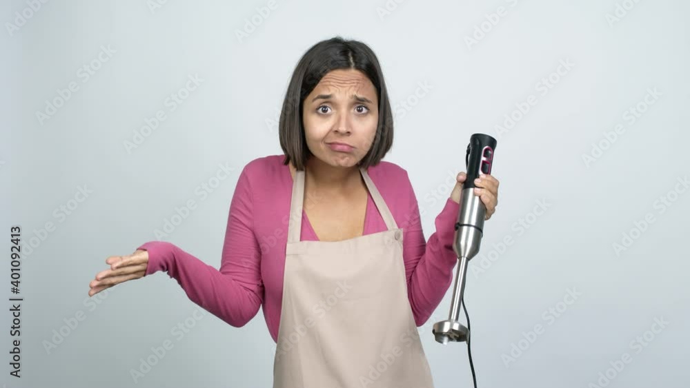 Young latin woman using hand blender having doubts over isolated background Young latin woman using hand blender having doubts over isolated background
