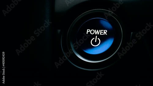 pushing blue Power ignition Button to start keyless ignition hybrid car engine photo