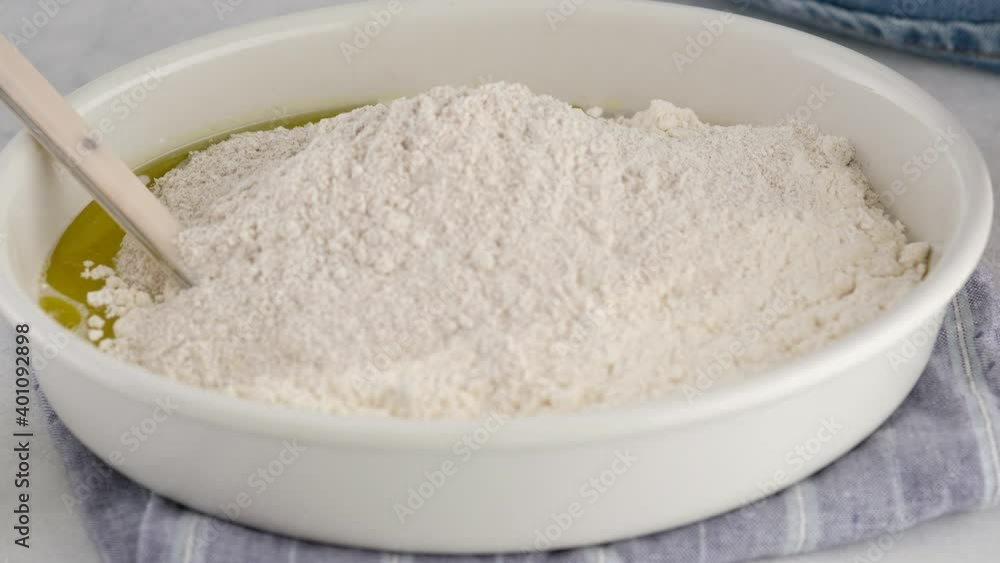 A woman pours flour and kneads a dough for bread in a ceramic mold. Cooking pizza. Baking bread. Cooking the ciabatta. Italian bread. Rye bread. 4K A woman pours flour and kneads a dough for bread in a ceramic mold. Cooking pizza. Baking bread. Cooking the ciabatta. Italian bread. Rye bread. 4K