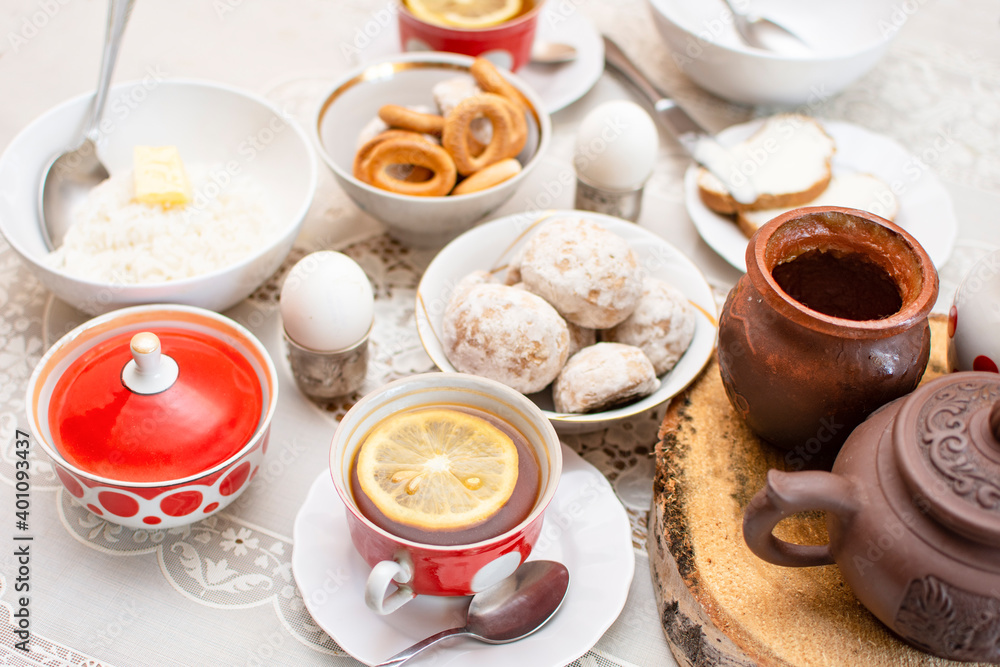 Traditional Russian or Ukrainian breakfast: eggs, rice porridge, honey, bagels (sushki) and tea with lemon. Traditional Russian or Belarusian cuisine. Russian traditional gingerbread cookies. Traditional Russian or Ukrainian breakfast: eggs, rice porridge, honey, bagels (sushki) and tea with lemon. Traditional Russian or Belarusian cuisine. Russian traditional gingerbread cookies.
