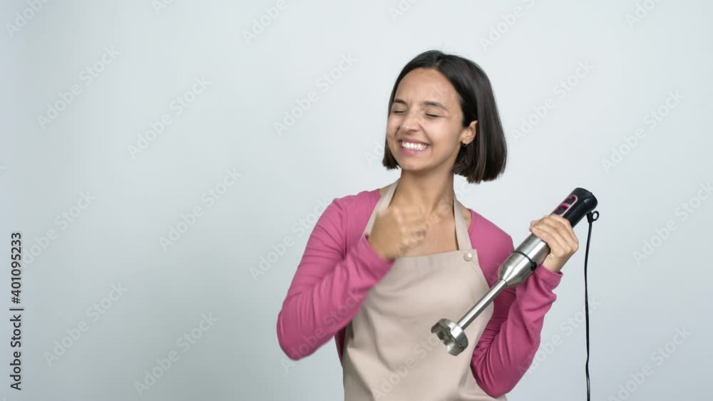 Young latin woman using hand blender intending to realizes the solution while lifting a finger up over isolated background Young latin woman using hand blender intending to realizes the solution while lifting a finger up over isolated background