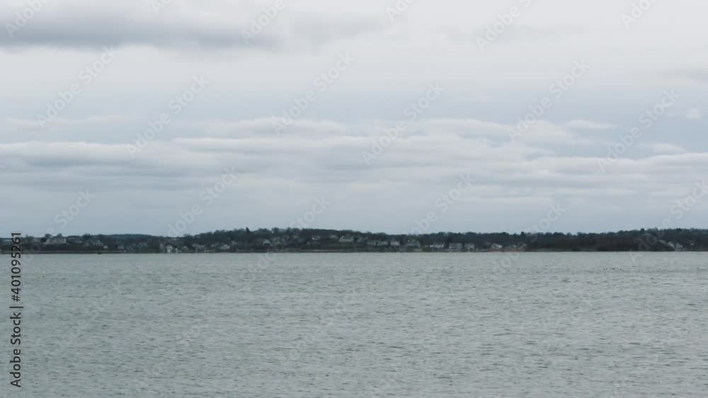 Seagull Flying Over The Bay On A Cloudy Day In Hull, Massachusetts Near Hull Gut And Boston Harbor - wide shot, static Seagull Flying Over The Bay On A Cloudy Day In Hull, Massachusetts Near Hull Gut And Boston Harbor - wide shot, static