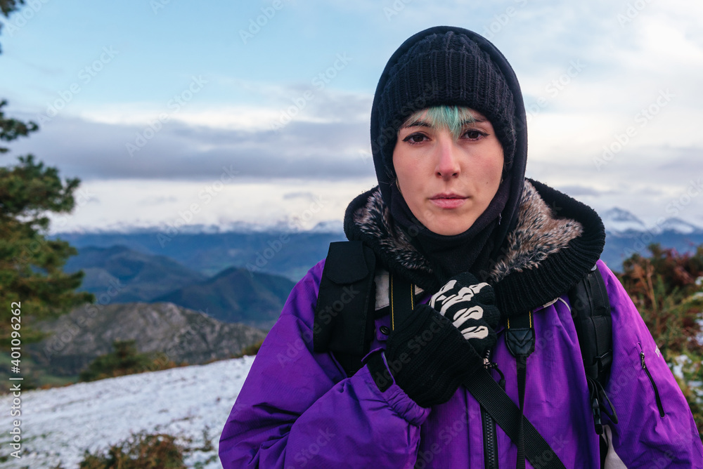 portrait of a young mountaineer woman with a serious gesture and her skin reddened and tanned by the cold and the wind of the mountain in winter. sport and adventure concept. portrait of a young mountaineer woman with a serious gesture and her skin reddened and tanned by the cold and the wind of the mountain in winter. sport and adventure concept.