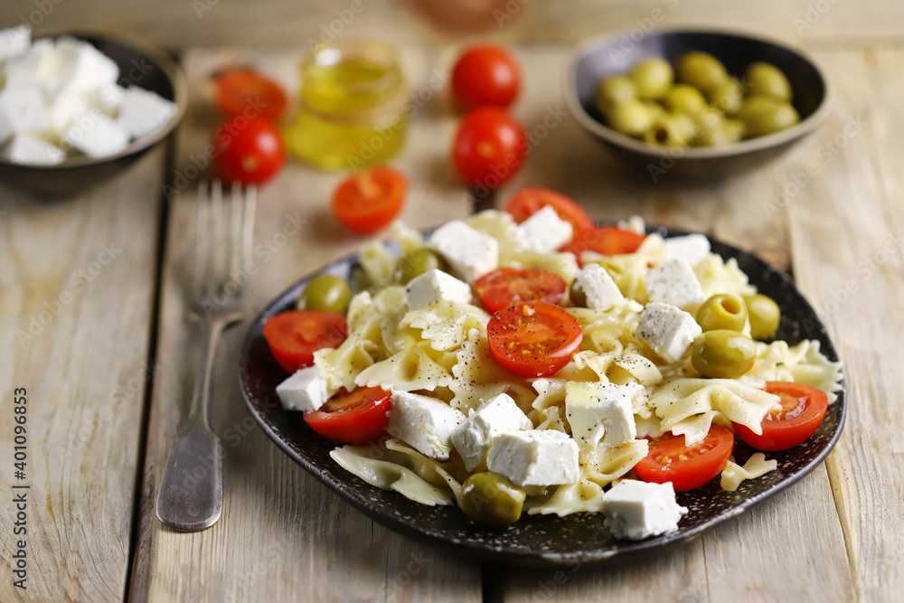 Selective focus. A plate of pasta with feta cheese and olives. Delicious healthy dinner. Italian style.