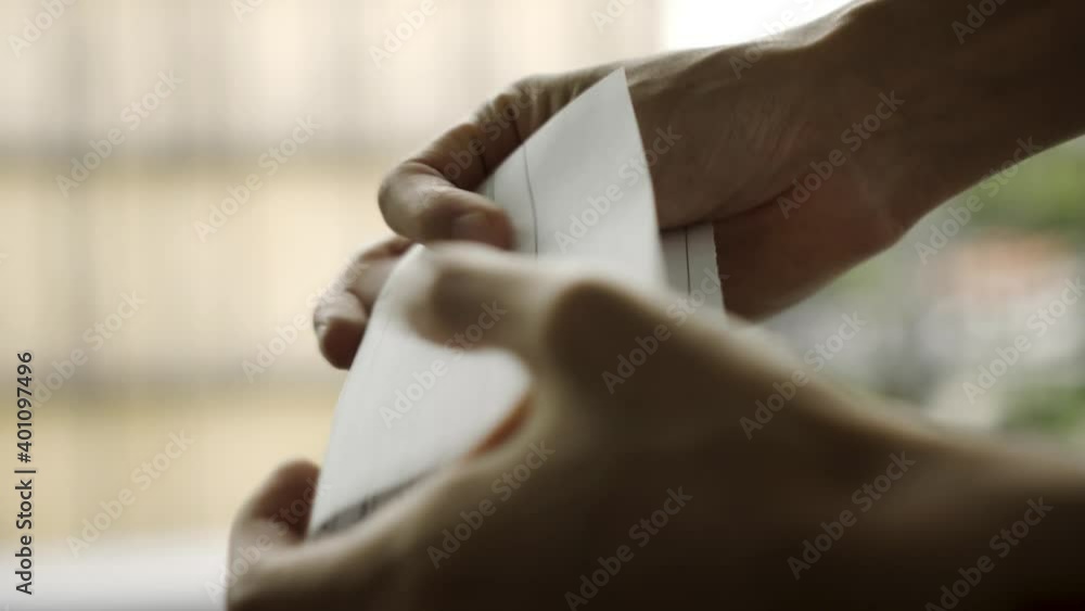 Close up of a person opening a piece of paper and handing it to another person while closing it Close up of a person opening a piece of paper and handing it to another person while closing it