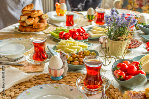 Happy family have breakfast together. Delicious rich Traditional Turkish breakfast include tomatoes  cheese  eggs  bagels  olives and tea cups. Ramadan Suhoor aka Sahur  morning meal before fasting . 