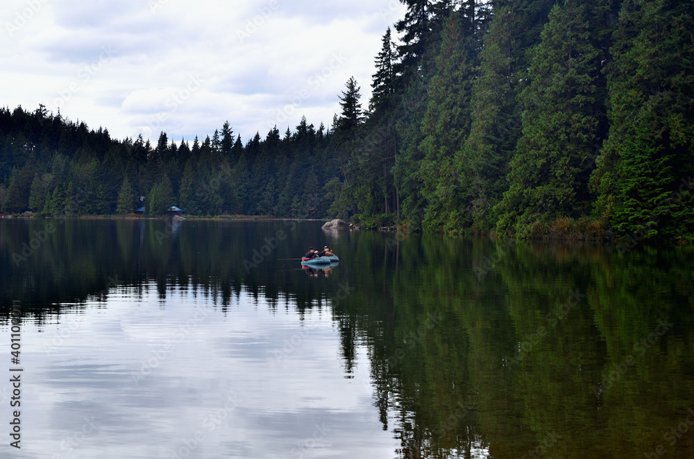 Fototapeta premium Placid Lake Surrounded with Old Forest 