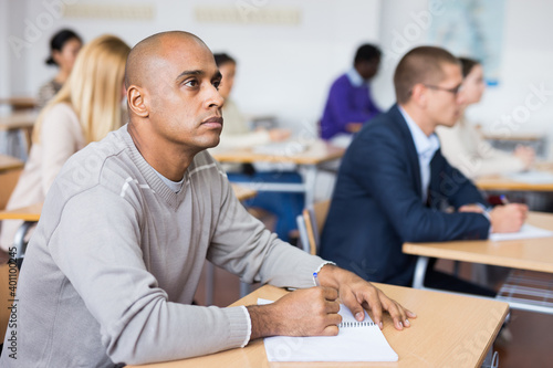 Portrait of a student at a desk in a university audience