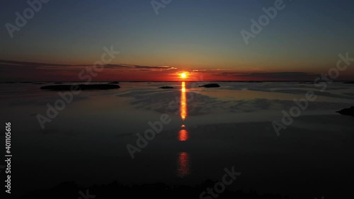 Aerial view over silhouette island and the open sea, during sunset, in the Saaristomeri archipelago of Finland - reverse, drone shot photo