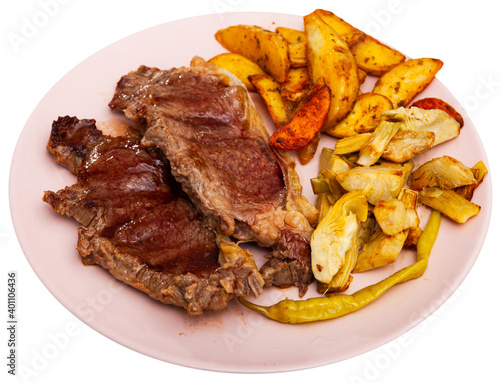 Tasty baked beef steak with potatoes and artichokes at the plate. Isolated over white background