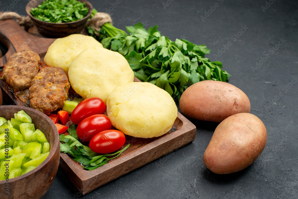 Cutlet meal with chopped vegetables a bunch of green and ketchup for dinner on dark background Cutlet meal with chopped vegetables a bunch of green and ketchup for dinner on dark background