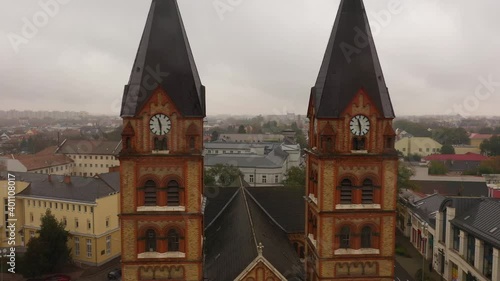 Drone footage from a Church in autumn rainy weather Nyiregyhaza, Hungary
Drone flies backwards and up between the towers photo