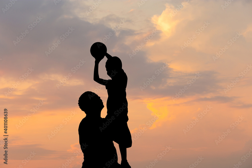 Silhouette of father and son with ball evening sky sunset background, Sport and enjoying life concepts.