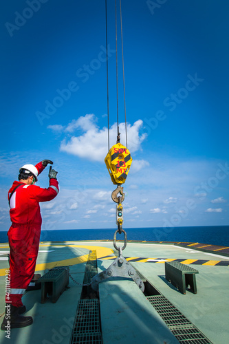Crane rigger during made the signal to crane driver for slowly winch up