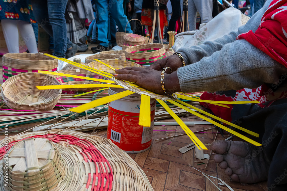 Young bengali woman's busy hands making wicker baskets , handicrafts on