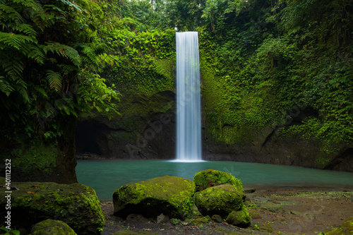 Waterfall landscape. Beautiful hidden waterfall in tropical rainforest. Nature background. Slow shutter speed, motion photography. Tibumana waterfall, Bali, Indonesia