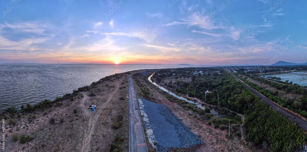 Aerial panorama view of beautiful road during Morning sunrise at the lake of Pa Sak Jolasid dam near the embankment in Lopburi province Thailand.