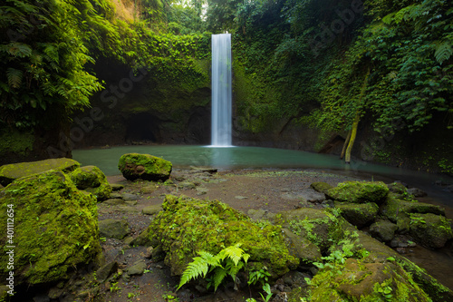 Panoramic view to waterfall in rainforest. Tropical landscape. Adventure and travel concept. Nature background. Slow shutter speed, motion photography. Tibumana waterfall Bali, Indonesia