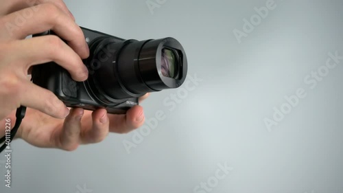 Using, zooming, and taking picture with  small superzoom point-and-shoot camera from Canon with white background studio shot photo