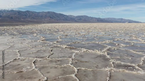 Salt rings in water at Badwater basin with Panamint mountains in the background at Death Valley National Park, CA, USA. Slider left to right.