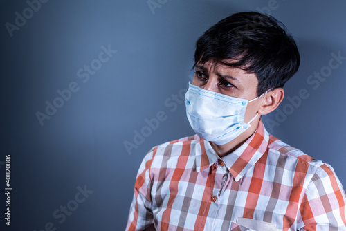 Portrait of young woman in protective mask is having fever and looking to the side