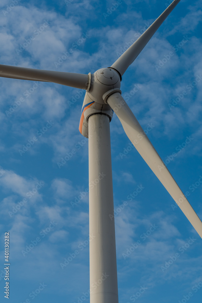 Electrical generating windmill against cloudy sky.