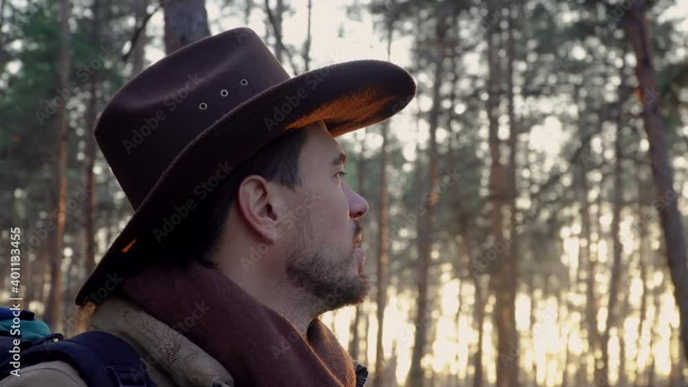 A man with a hat and a backpack in the forest. Close-up. Travel concept A man with a hat and a backpack in the forest. Close-up. Travel concept