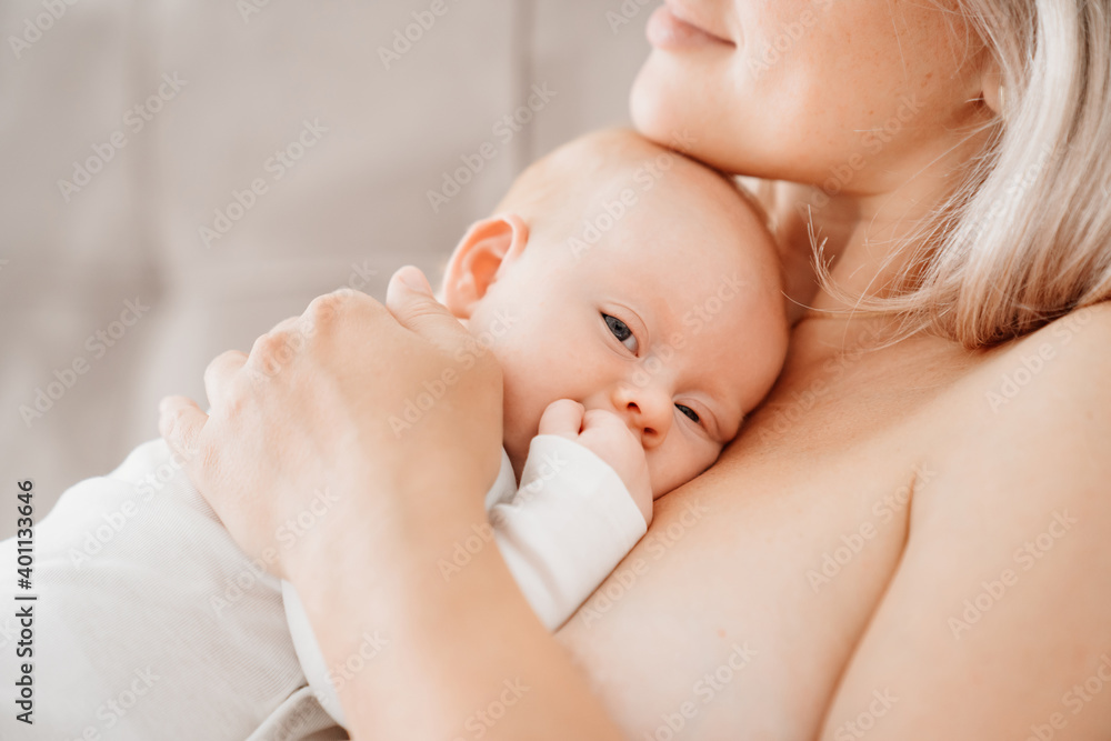 mom is mom is lying down with a baby in a white bed after feeding breast milk.  - obrazy, fototapety, plakaty 