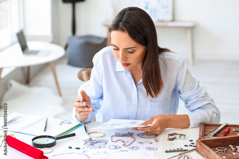 Female jewelry designer working in office Female jewelry designer working in office