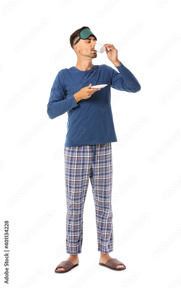 Portrait of young man with sleep mask drinking coffee on white background Portrait of young man with sleep mask drinking coffee on white background