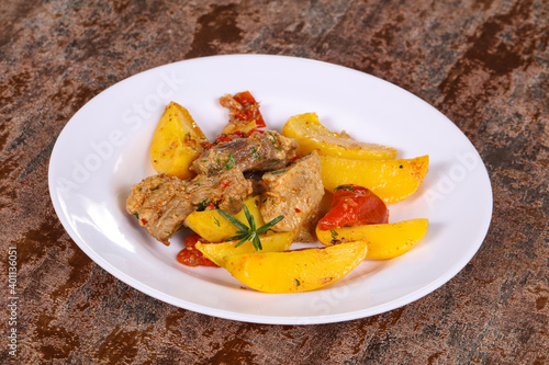 Baked pork meat with potao and tomato photo