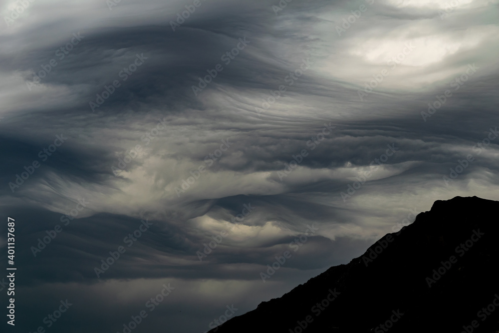 stormy weather front with thick grey clouds with a mountain silhouette stormy weather front with thick grey clouds with a mountain silhouette