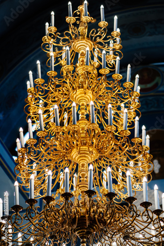 beautiful large gold chandelier candle holder on the ceiling in the Church.