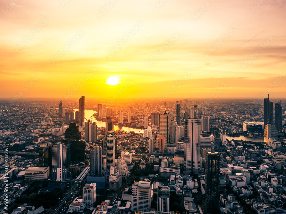 Aerial view of Bangkok skyscraper with orange sky sunset. Citysapce and Chao Phraya River in Thailand Capital