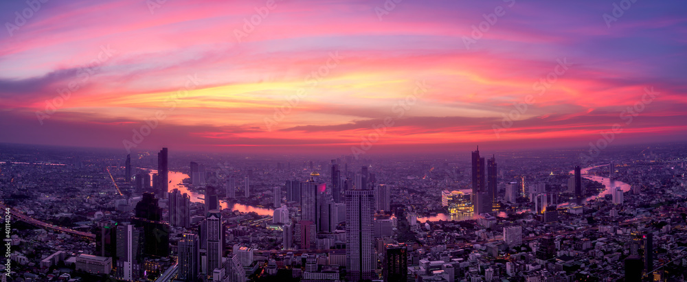 Aerial view of Bangkok skyscraper with orange sky sunset. Panorama of Citysapce and Chao Phraya River, Thailand