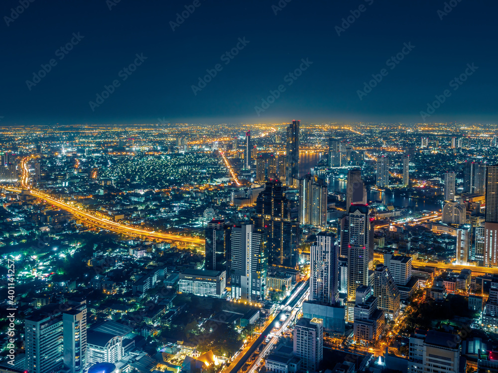 Aerial view of Bangkok skyscraper with light tail at night. Citysapce in Thailand Capital