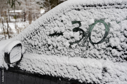 frozen car window with the inscription weather forecast minus 30 photo