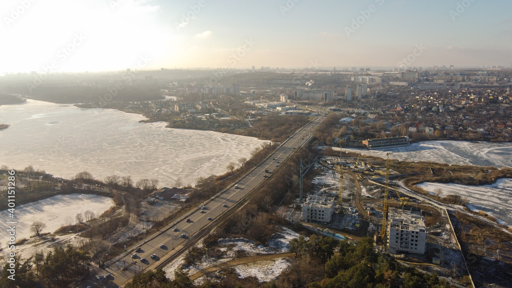 Frozen city road. Winter aerial cityscape of town with road. Splendid morning view from dron.