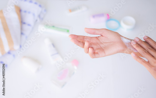 Hand apply moisturizer on blur background. lotion, skin cream, sunscreen, skin care serum. beauty and healthcare concept.