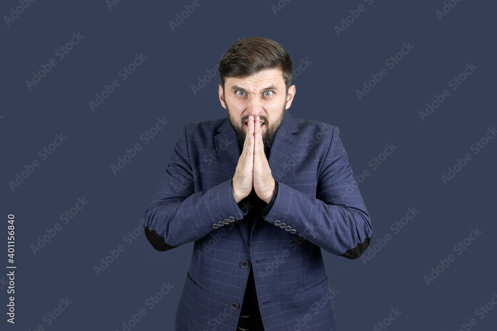 a man with a beard and a blue suit folded his hands, palms facing each other a man with a beard and a blue suit folded his hands, palms facing each other