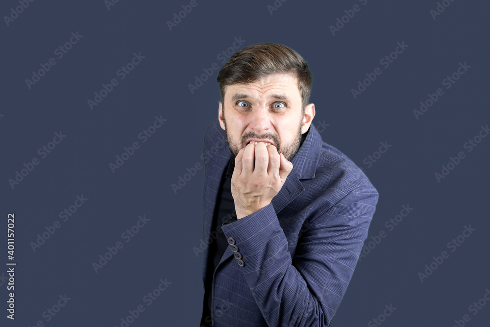 a bearded man in a blue suit bites his nails in fear a bearded man in a blue suit bites his nails in fear